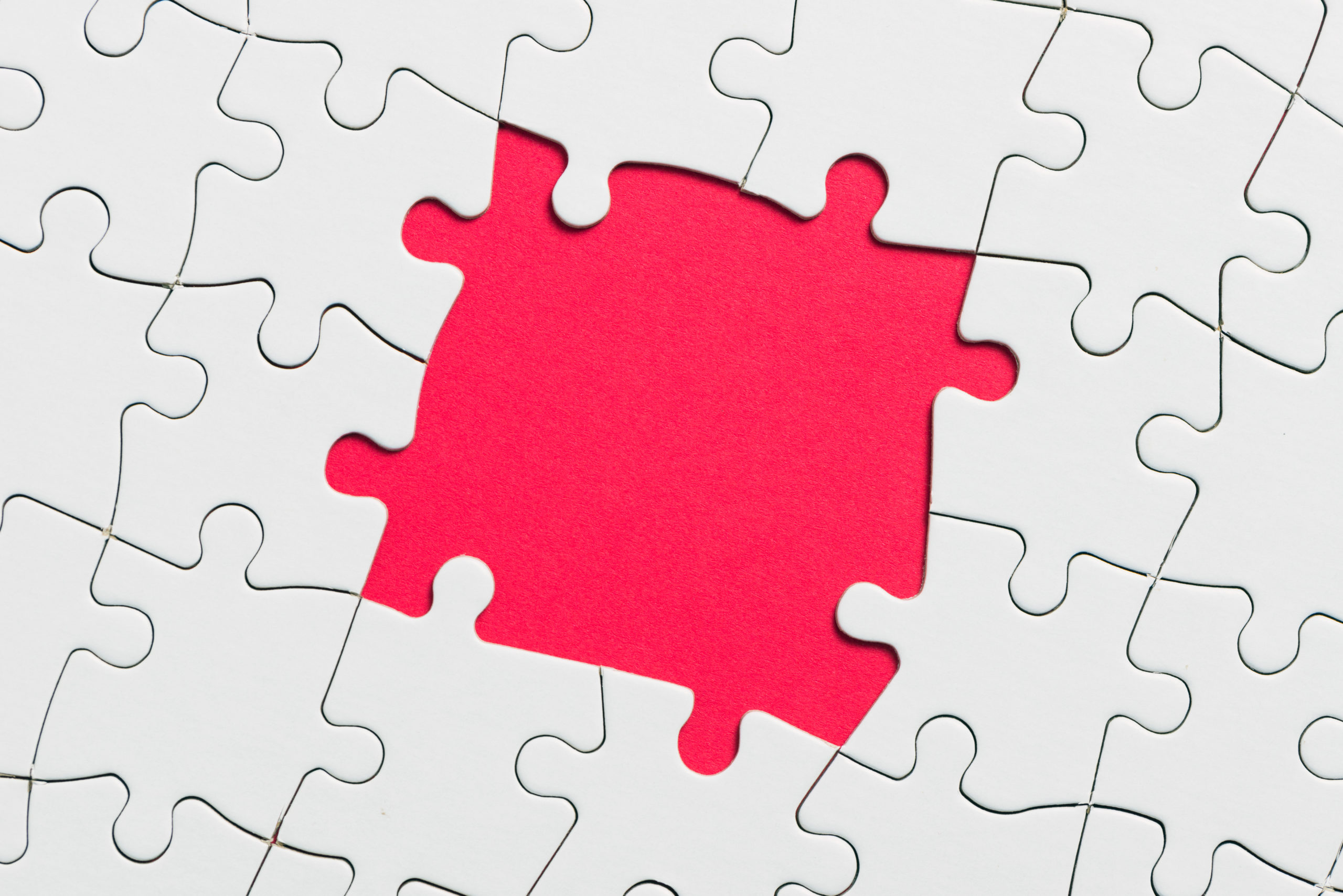 White jigsaw puzzle game pieces on red background form a banner for business theme design